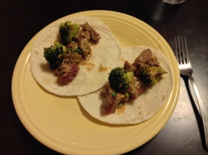 cut up steak with broccoli and peanut sauce in small tortillas